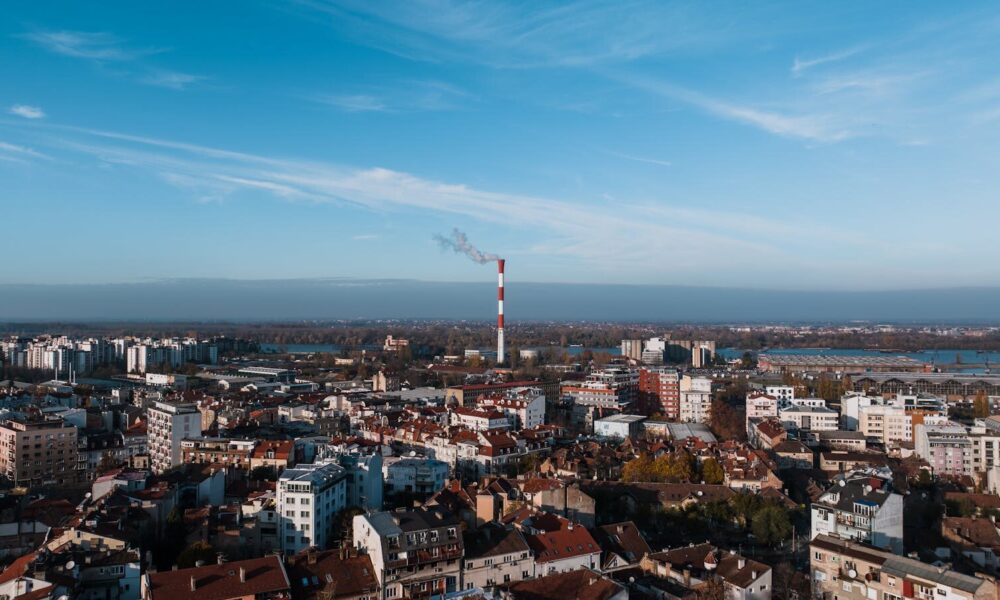 A stunning aerial view of Belgrade, Serbia featuring urban architecture and a prominent smoke stack.