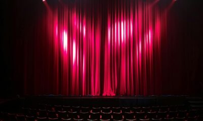 Empty theater stage with red curtains and seating, ready for a performance.