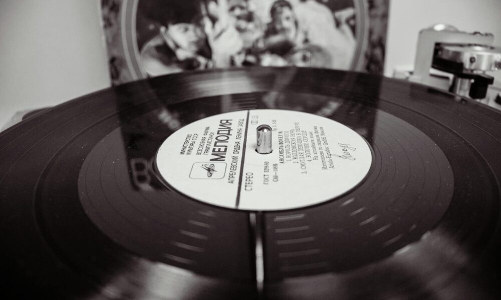 Black and white close-up of a spinning vinyl record on a turntable.