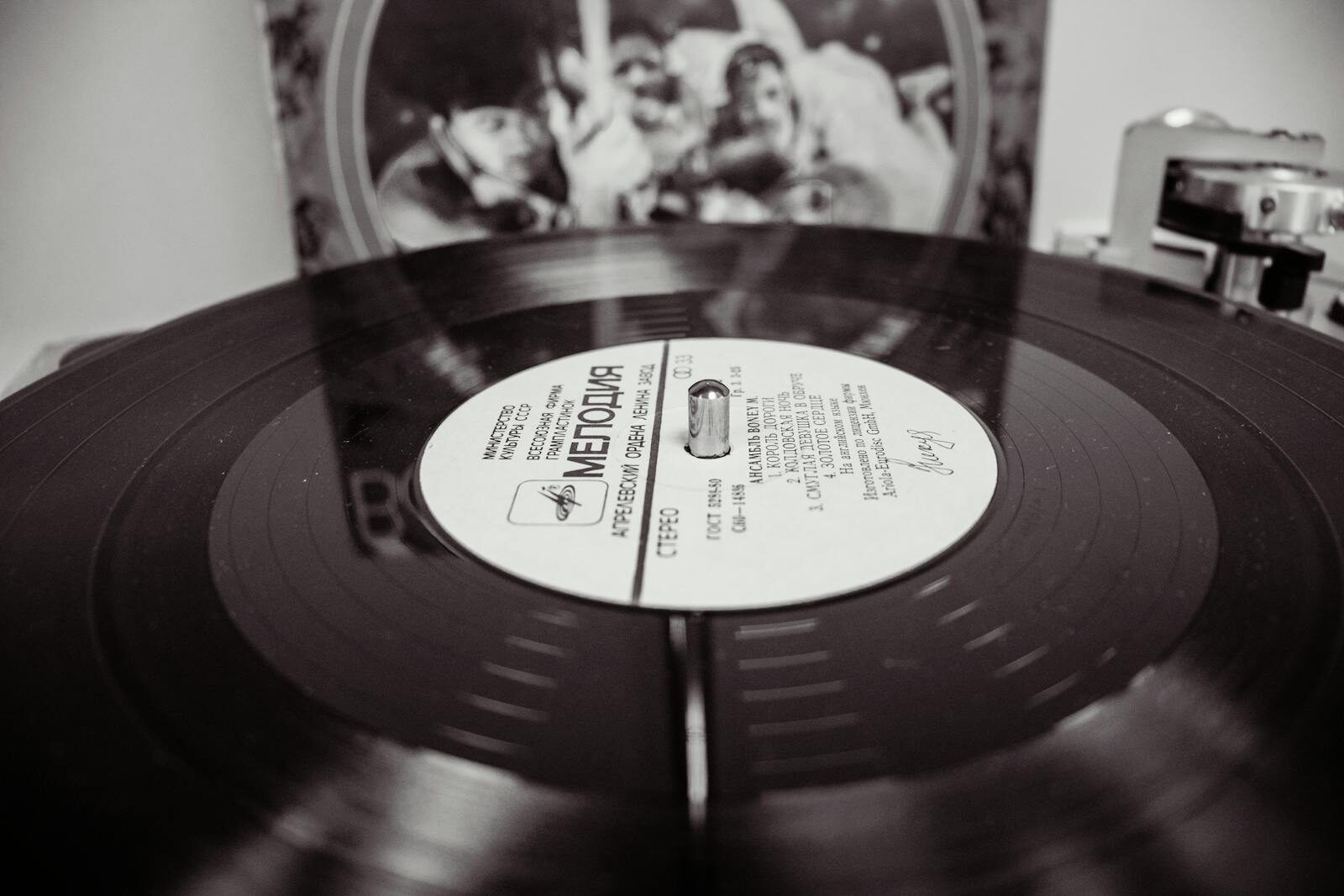 Black and white close-up of a spinning vinyl record on a turntable.