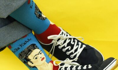 Stylish artistic socks featuring Frida Kahlo design with black sneakers on a vibrant yellow background.