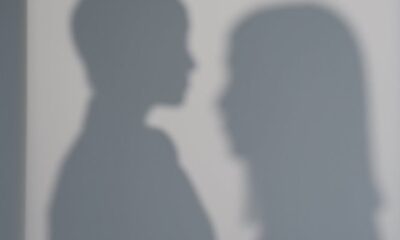 Two women's shadows cast on a wall creating an artistic silhouette effect.