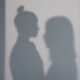 Two women's shadows cast on a wall creating an artistic silhouette effect.