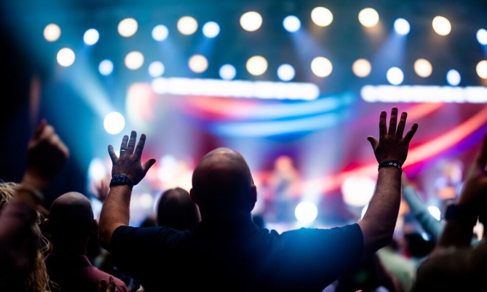 A vibrant scene of concert-goers enjoying a live music performance with colorful stage lights.