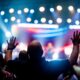 A vibrant scene of concert-goers enjoying a live music performance with colorful stage lights.