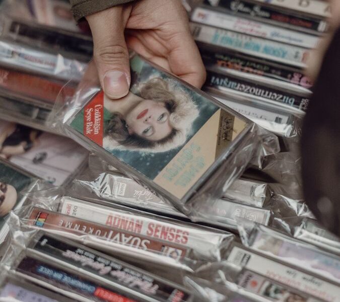 Person browsing vintage cassette tapes at an Istanbul market, evoking nostalgia for retro music lovers.