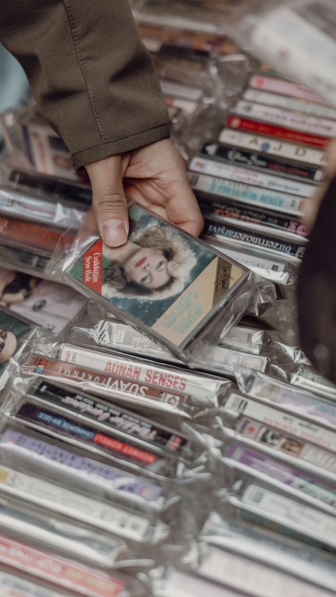 Person browsing vintage cassette tapes at an Istanbul market, evoking nostalgia for retro music lovers.